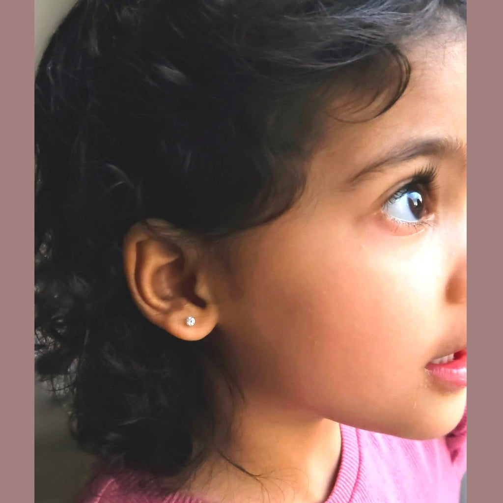 Close-up of a young girl wearing a pink sweater with a neutral background
