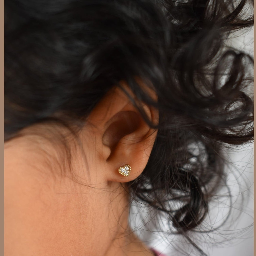 Close-up of an ear wearing a diamond earring with blurred background